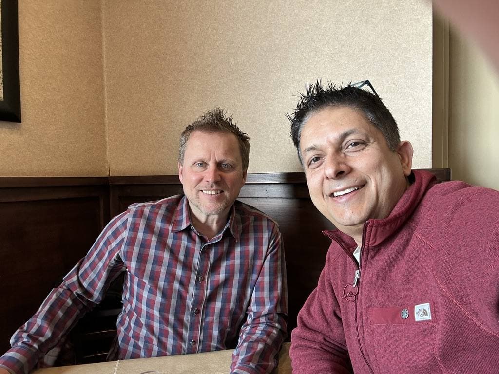 Aruneesh Salhotra with a colleague at a restaurant on the conference circuit
