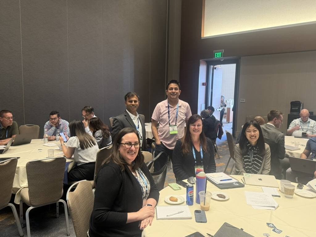 Aruneesh Salhotra in a workshop room with attendees at round tables