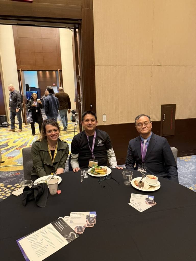 Aruneesh Salhotra with a colleague at a conference hallway