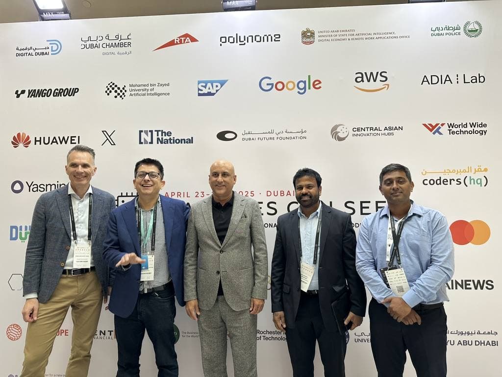 Aruneesh Salhotra with colleagues at the Machines Can See 2025 media wall in Dubai