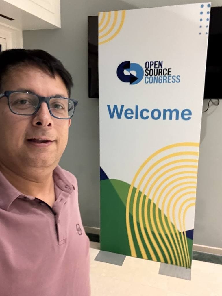 Aruneesh Salhotra by the Open Source Congress welcome banner in Brussels