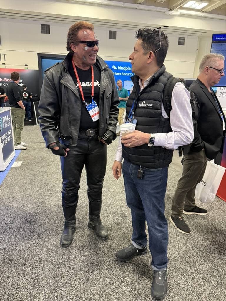 Aruneesh Salhotra talking with a costumed vendor mascot on the RSAC 2026 expo floor