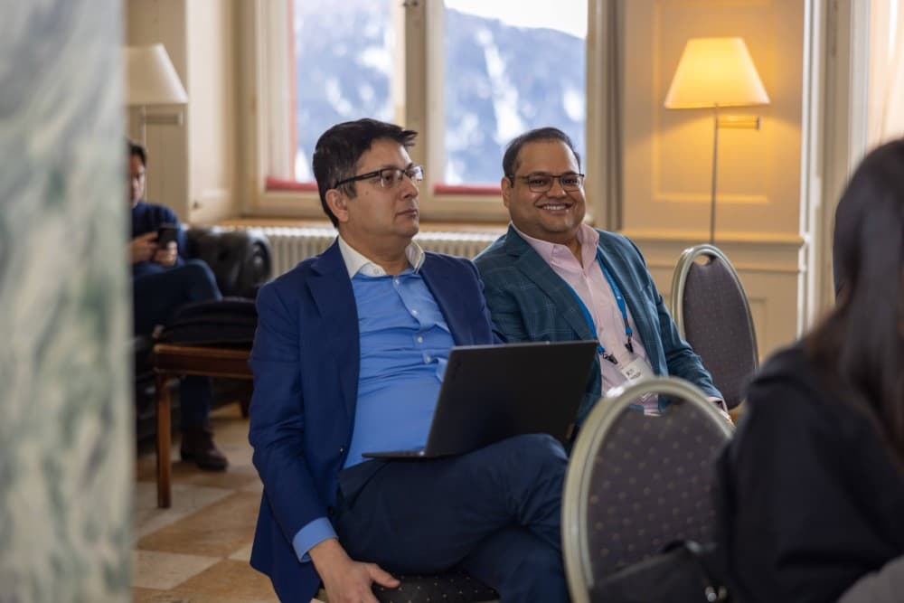 Aruneesh Salhotra seated with a colleague at the World Economic Forum